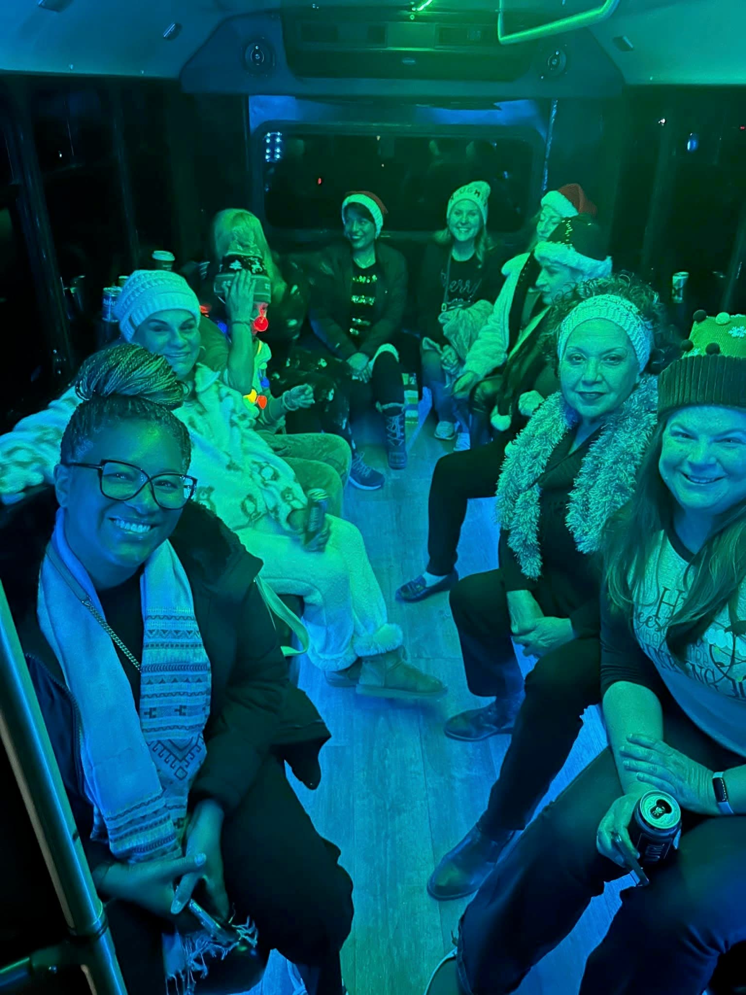 A holiday party in sweaters and beanies under the 16's teal lights