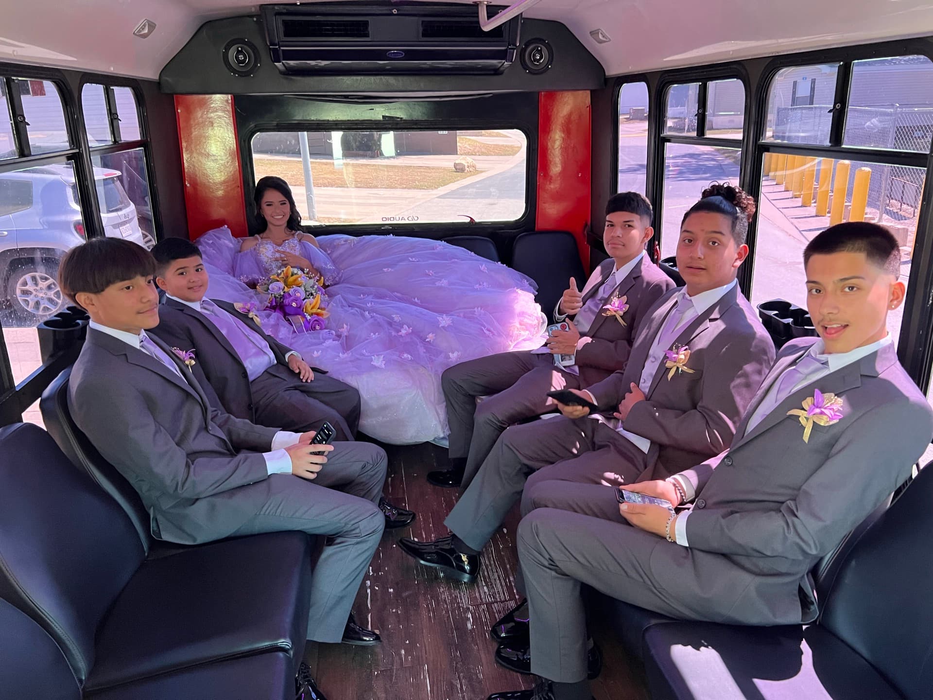 Groomsmen in gray suits with boutonnieres seated along the 16's benches